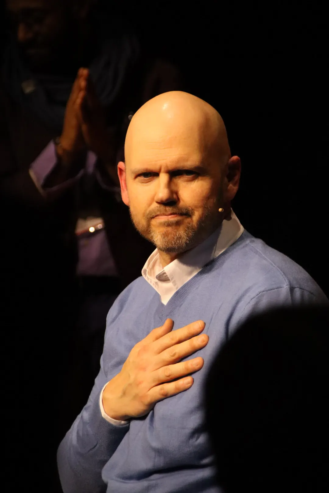 Jeff D. Harmon on stage with his hand over his heart